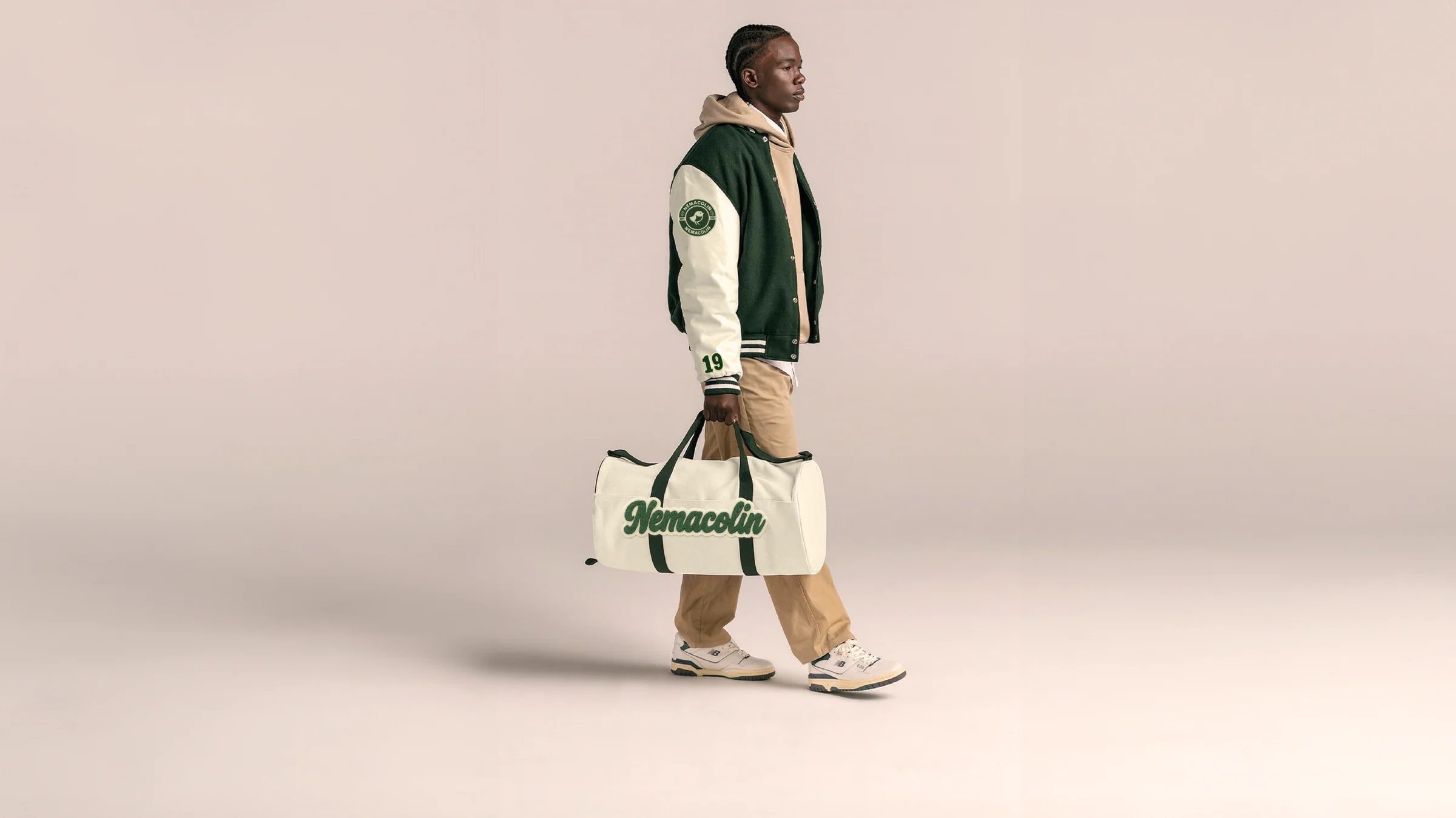 Nemacolin heritage duffel bag held by a model in a soft studio setting